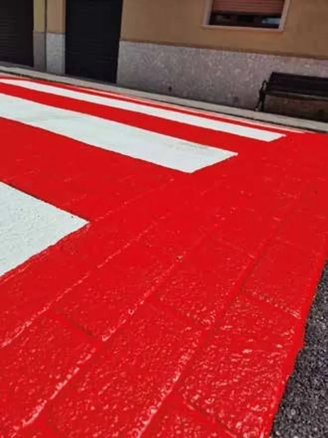 Attraversamento pedonale in resina rossa con strisce bianche