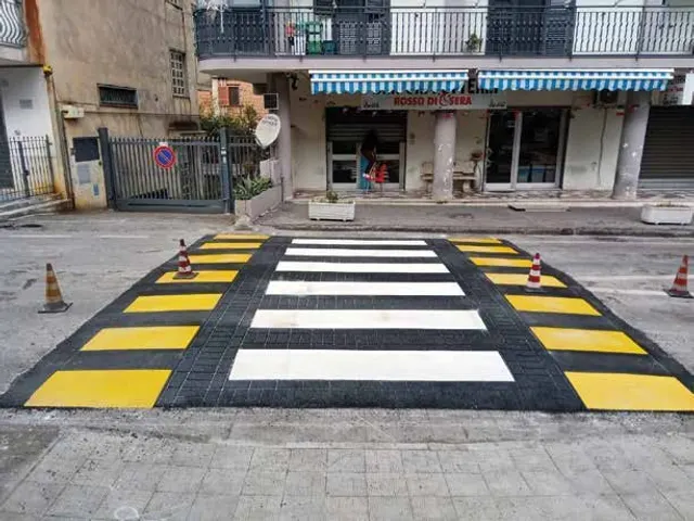 Attraversamento pedonale rialzato con fasce bianche e gialle