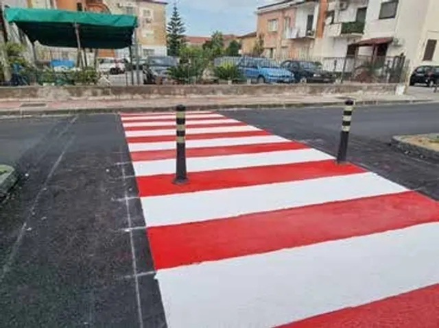 Attraversamento pedonale rialzato rosso e bianco con dissuasore