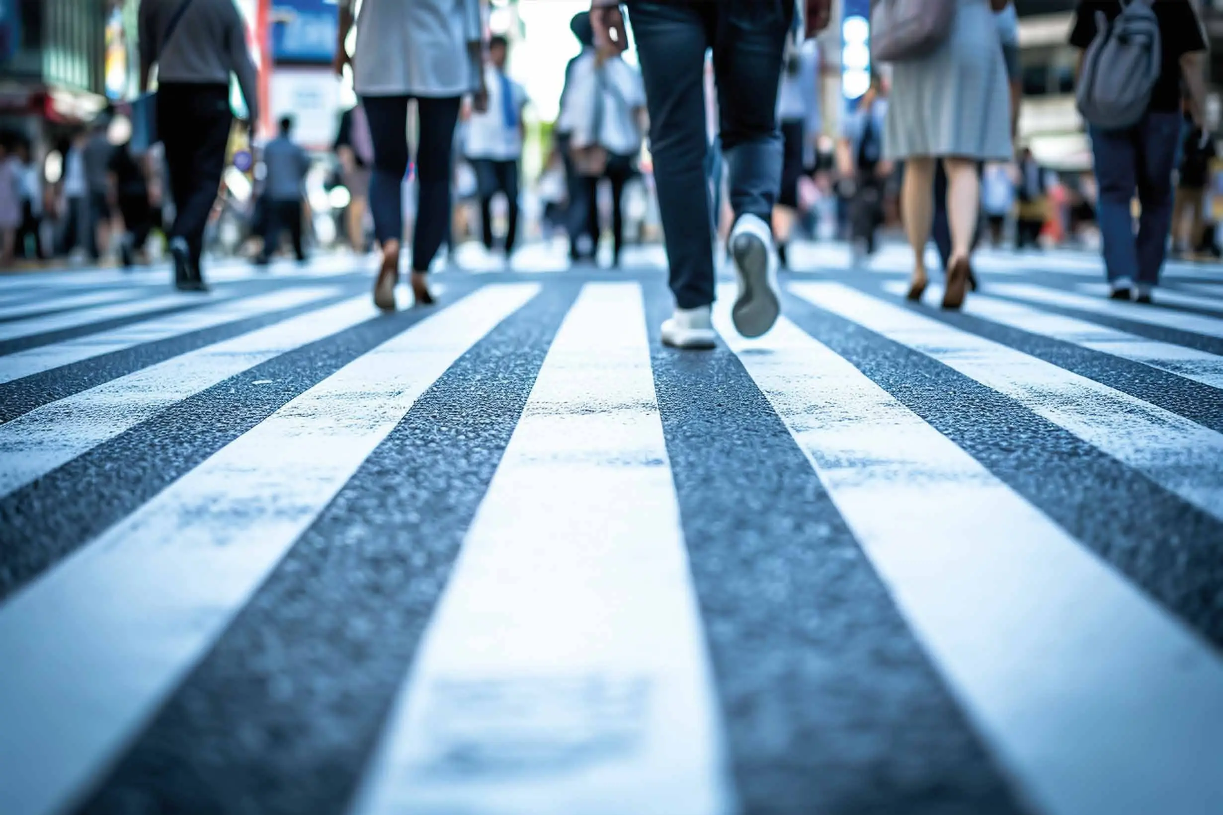 Attraversamento pedonale con segnaletica orizzontale bianca percorso da pedoni